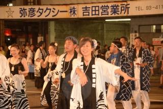 白黒の衣装を着た人たちが、集まって笑顔で踊っている写真