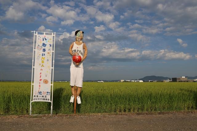 バスケットボールを胸に抱えた選手を模している案山子の写真