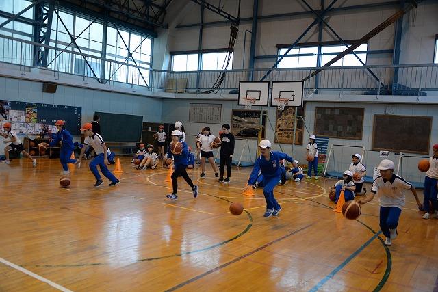 体育館内でバスケットボールのドリブル練習をしている子ども達の写真