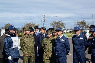 自衛隊の隊服を着た男性たちと青い制服の男性たちが並んで立っている写真