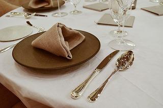 テーブルの上に食器と金色のカトラリーが並んでいる写真