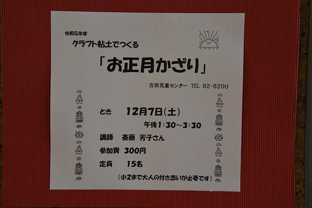 クラフト粘土でつくる「お正月かざり」のイベントに関する説明が書かれた用紙が貼られた茶色の板の写真