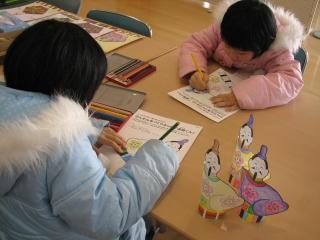 紙と色鉛筆で工作する児童の写真