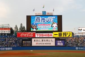 野球の試合時のバックスクリーンに燕市の燕と花魁のキャラクターと「燕市」の文字が青色をバックとして表示されている写真