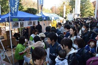 青いテントの東京ヤクルトスワローズファン感謝Day出店の前に大勢のお客が集まっているの写真