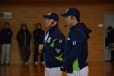 選手が2人帽子を被ってインカムを付けて、話をしている写真