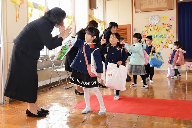 先生とハイタッチする園児たちの写真