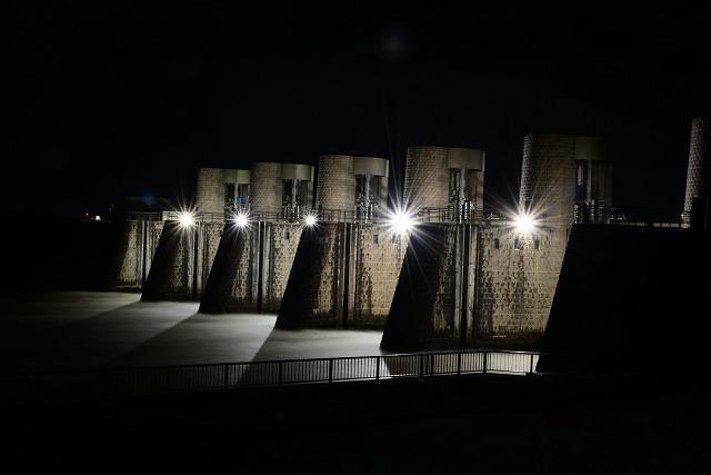 夜空の下、5台並んだ建造物から強い光がそれぞれ発射されている写真