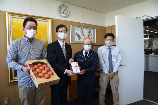 マスクをつけた市長がトマトのご寄付を頂いている写真