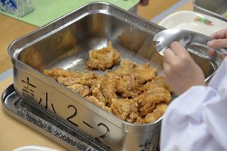 金属製の四角い食缶に入ったたくさんの鶏肉のレモン和えの写真