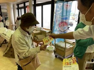 店内で応募はがきを配っている職員の写真