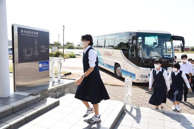 燕市産業史料館看板を前に、入場しようとする生徒たちの写真