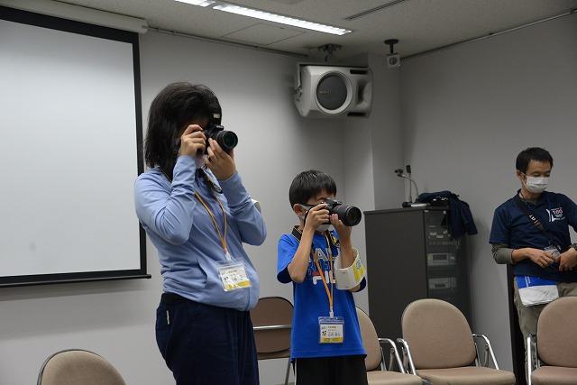 カメラを構える女性と男の子の写真