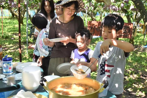 鍋から豚汁をよそう男の子