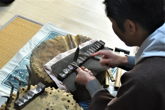 金属の筒を金槌で叩いて形を整える岩浪さん