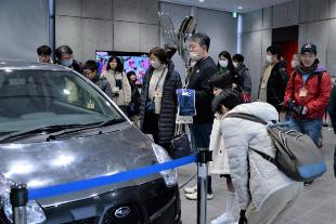ピカピカに研磨された車の展示を眺める参加者