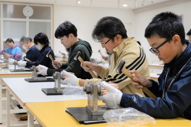真剣にタンブラーをハンマーで叩く参加者の皆さん