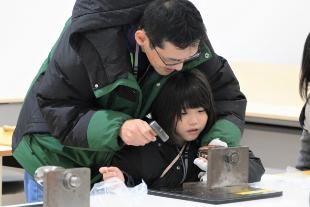 鎚目入れ体験を楽しむ親子