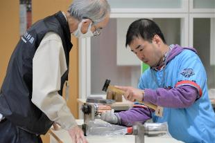 工房館スタッフにアドバイスされながらタンブラーを叩く参加者