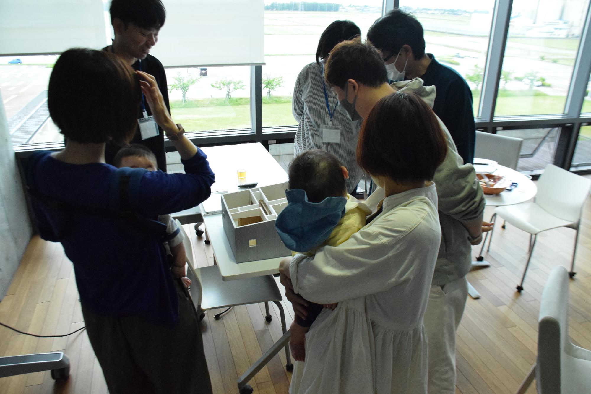 住宅の模型を見ながら構想を練っている交流会参加者たち